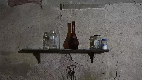 Glass jars and bottle casting moving shadows on a rustic wall Stock Footage 320407457