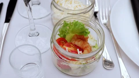 Glass jars displaying layered caesar salad featuring grilled shrimp, vibrant Stock Footage 331463336