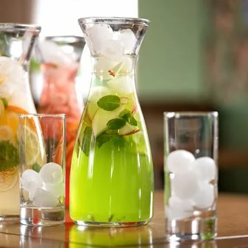 Glass jars with mixed fruit refreshments and glasses with ice on bar or Stock Photos