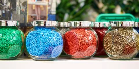 Glass jars with samples of plastic colored granules Stock Photos