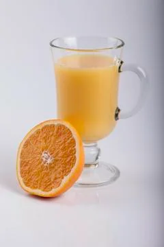 Glass of juice and a sliced orange on white Foto stock