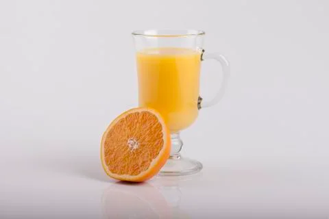 Glass of juice and a sliced orange on white Stock Photos