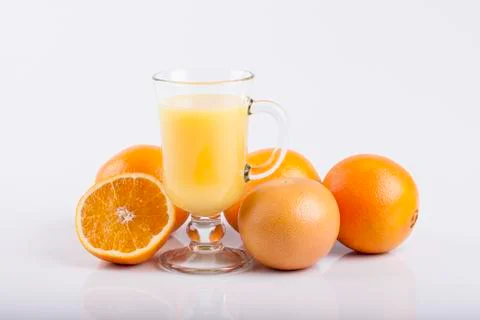 Glass of juice and a sliced orange on white Stock Photos