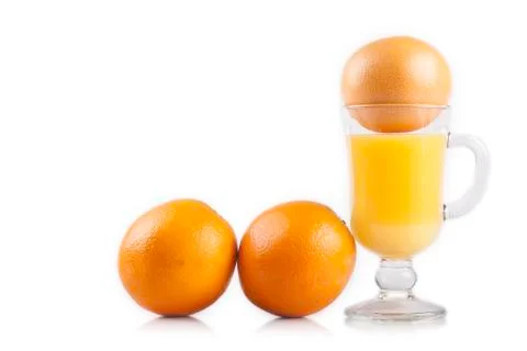 Glass of juice and a sliced orange on white Stock Photos