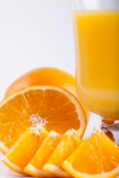 Glass of juice, sliced orange on white closeup Stock Photos