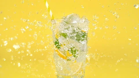 Glass with Lemonade Splashed by Stream of Water in Slow Motion 1000fps Stock Footage 142286112