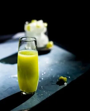 Glass of lemonade on table with a dark light background. Fresh lemon juice .. Stock Photos