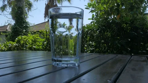 A glass of lemonade on a table with a green background. Soda with gas bubbles Video stock 80298433