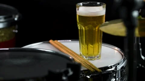 Glass of light beer on professional drum set closeup. Stock Footage 147945248
