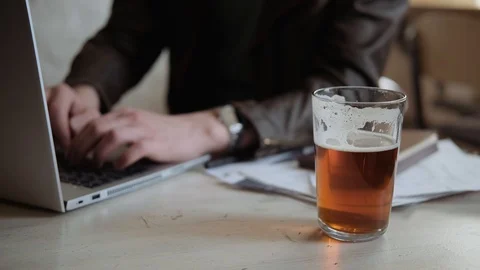 Glass with light beer on the table with laptop and documents, close up Stock-Footage 127477016