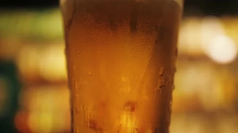Glass of light lager beer on a dark pub. Stock Footage 207137945