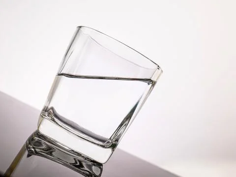 Glass for liquor Translucent elements made of glass are placed on a tilted .. Stock Photos