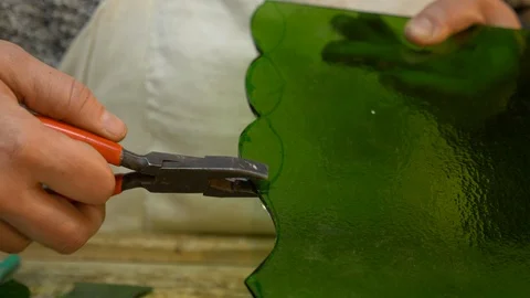 Glass-maker pulls piece of green glass Stock Footage 119477669