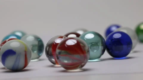 Glass marble balls playing rolling hitting clashing on white background  Stock Footage 182681389