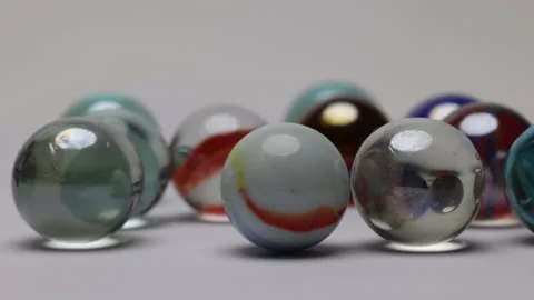 Glass marble balls playing rolling hitting clashing on white background  Stock-Footage 182686164