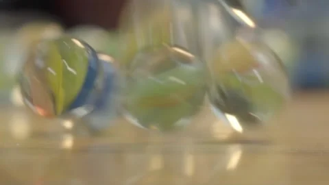 Glass marbles falling from mesh bag in slow motion Stock Footage 325364584