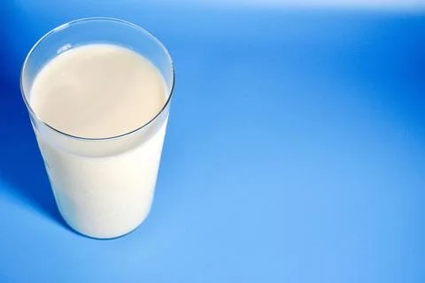 A glass of milk on blue background with empty copy space Stock Photos
