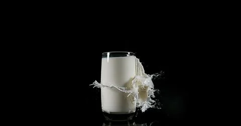 Glass of Milk Exploding against White Background 写真素材