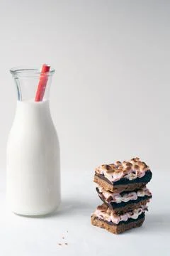 A glass of milk sits next to a stack of brownies Stock Photos