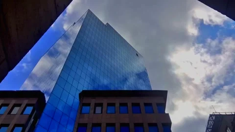 Glass Mirrored Building With Dark Clouds And Sun Lens Flare Stock Footage 196741459