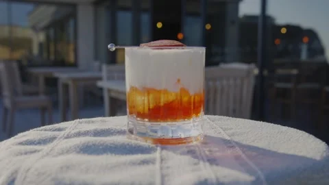 A glass of mixed drink sits on a table Stock Footage 306576207