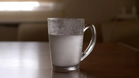 Glass Mug With Cold Effervescent Liquid And Condensation On Table 库存影片 330299161