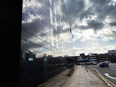 Glass office building with dramatic cloud reflections on a Manchester, UK s.. Stock Photos