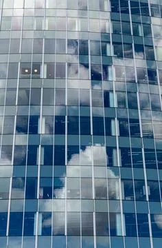 Glass office building facade with cloud reflections Stock Photos