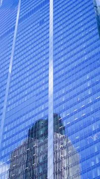 Glass office skyscraper with blue reflections dominating the city sky line. Stock Photos