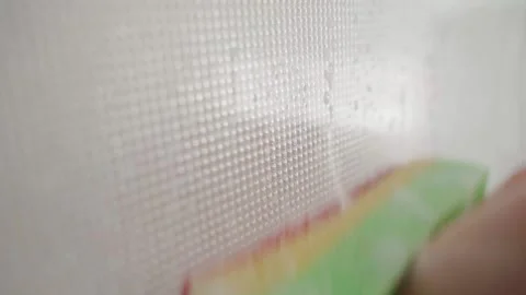 A glass opaque window being washed with a sponge and soapy water close-up Stock Footage 204028115
