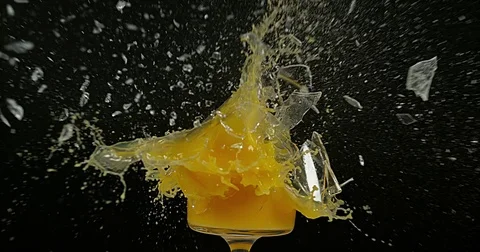 Glass of Orange Exploding against Black Background, Slow Motion 4K Stock Footage 75977038