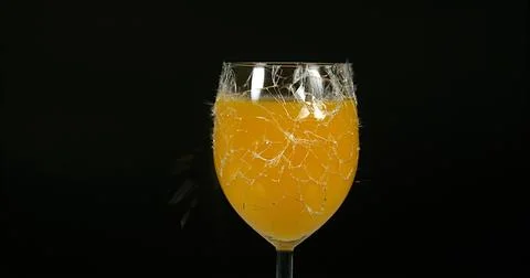 Glass of Orange Exploding against Black Background Stock Photos