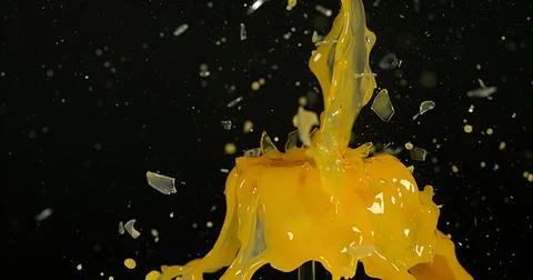 Glass of Orange Exploding against Black Background 스톡 사진