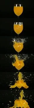 Glass of Orange Exploding against Black Background Foto stock