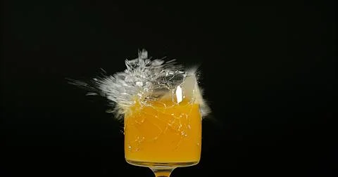 Glass of Orange Exploding against Black Background 스톡 사진