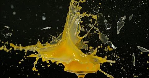 Glass of Orange Exploding against Black Background Stock Photos