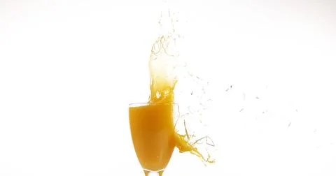 Glass of Orange Exploding against White Background 스톡 사진