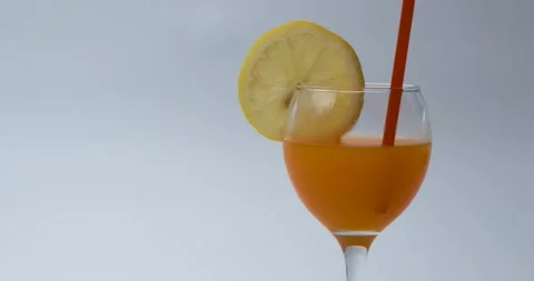 Glass of orange juice with lemon slice and straw Stock Footage 148876643