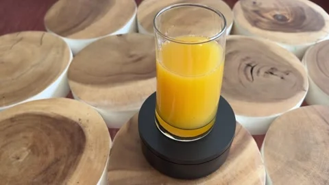 Glass of orange juice rotating on turntable Stock Footage 333597110