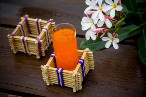 A glass of orange juice with water glass holder made of bamboo sticks and fib Stock Photos