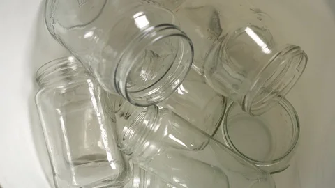 Glass Packaging. Empty clear glass bottles and jars. Household Waste Disposal Stock Footage 127211494