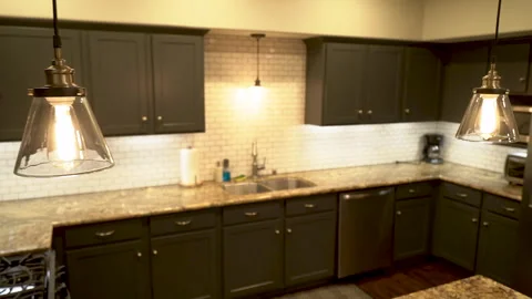 Glass pendant lamp over kitchen sink and dark cabinets Stock Footage 345691891