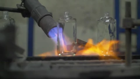 Glass perfume flasks being heated by flame Stock Footage 271353657
