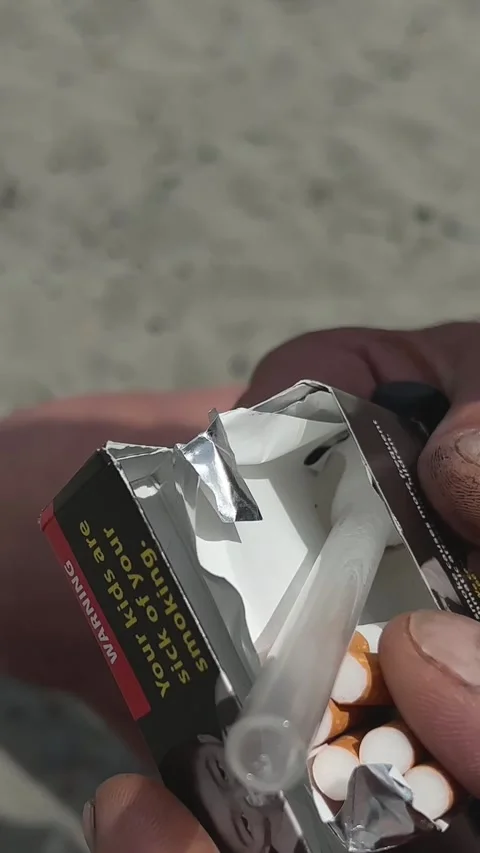 A glass pipe a flask for smoking in the hands of a man to light a drug bums in Stock Footage 245956442
