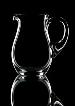 Glass pitcher on a black background Stock Photos