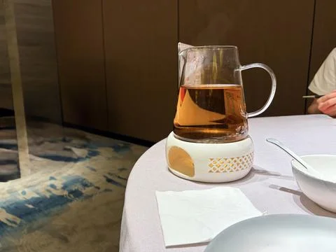 Glass Pitcher of Tea on Table in Modern Dining Setting Fotos de archivo