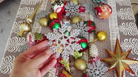 Glass, plastic, Christmas tree decorations on white tablecloth. Womens hands Stock Footage 143959664