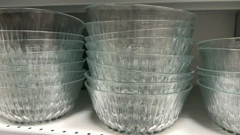 Glass plates displayed on gray store shelves in a kitchenware department for Stock Footage 345172664