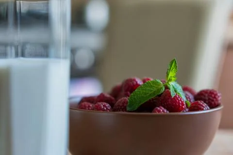 Glass of raspberry milk shake with berries on bright background Stock Photos