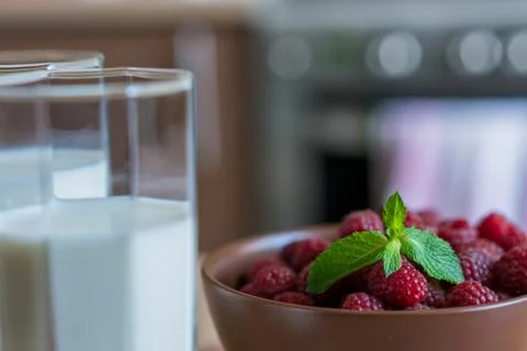 Glass of raspberry milk shake with berries on bright background Stock Photos